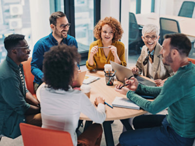 A group of people sitting around the table and working.