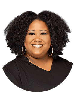 A woman with afro hair smiling in a black shirt.