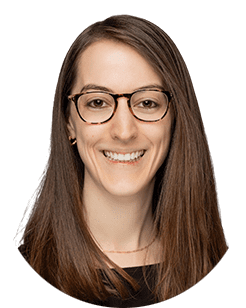 A smiling woman wearing glasses and a black shirt.