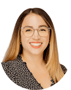 A smiling woman wearing glasses and a black shirt.