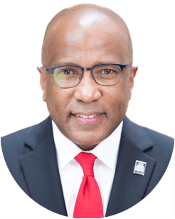 A person with glasses wearing a suit, white shirt, and red tie.