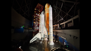 The space shuttle Endeavor stands upright in a museum.