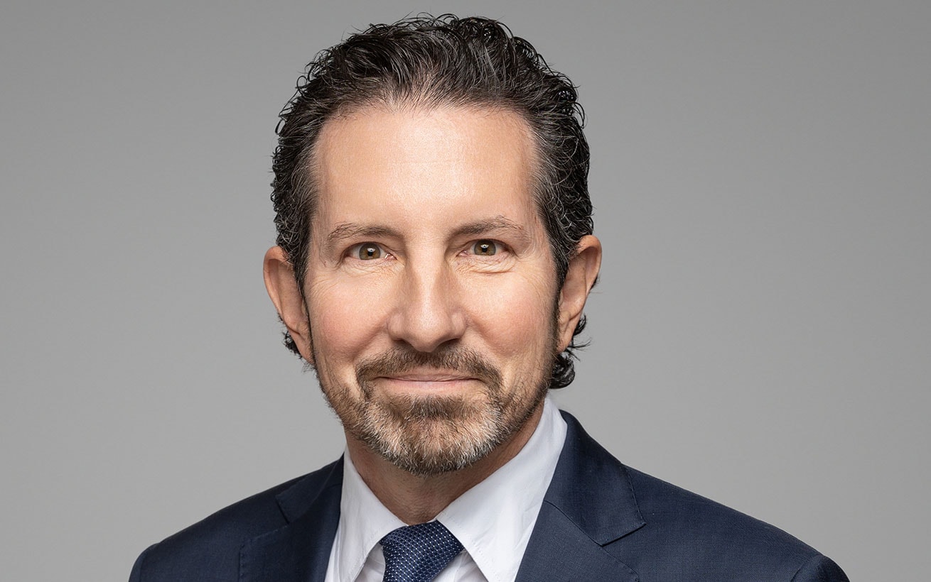 A headshot of Richard Phillips wearing a suit