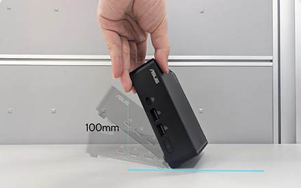 Một bàn tay người thả một hộp linh kiện máy tính xuống bàn. Hộp có ghi '100mm' ở bên cạnh.