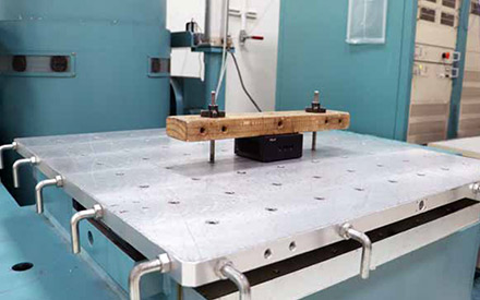 Thiết bị công nghiệp trong phòng thí nghiệm có máy móc, bảng điện, cáp được kết nối với hộp các tông lớn trên giá đỡ
