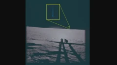 Ой юзасидан олинган фотосурат. Унда икки космонавтнинг соялари ва узоқда кўк чироқ чақнашига ўхшаш нарса кўрсатилган. У белгиланган ва катталаштирилган