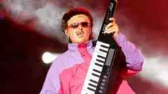 Tree hold piano, e wear pink and purple dress