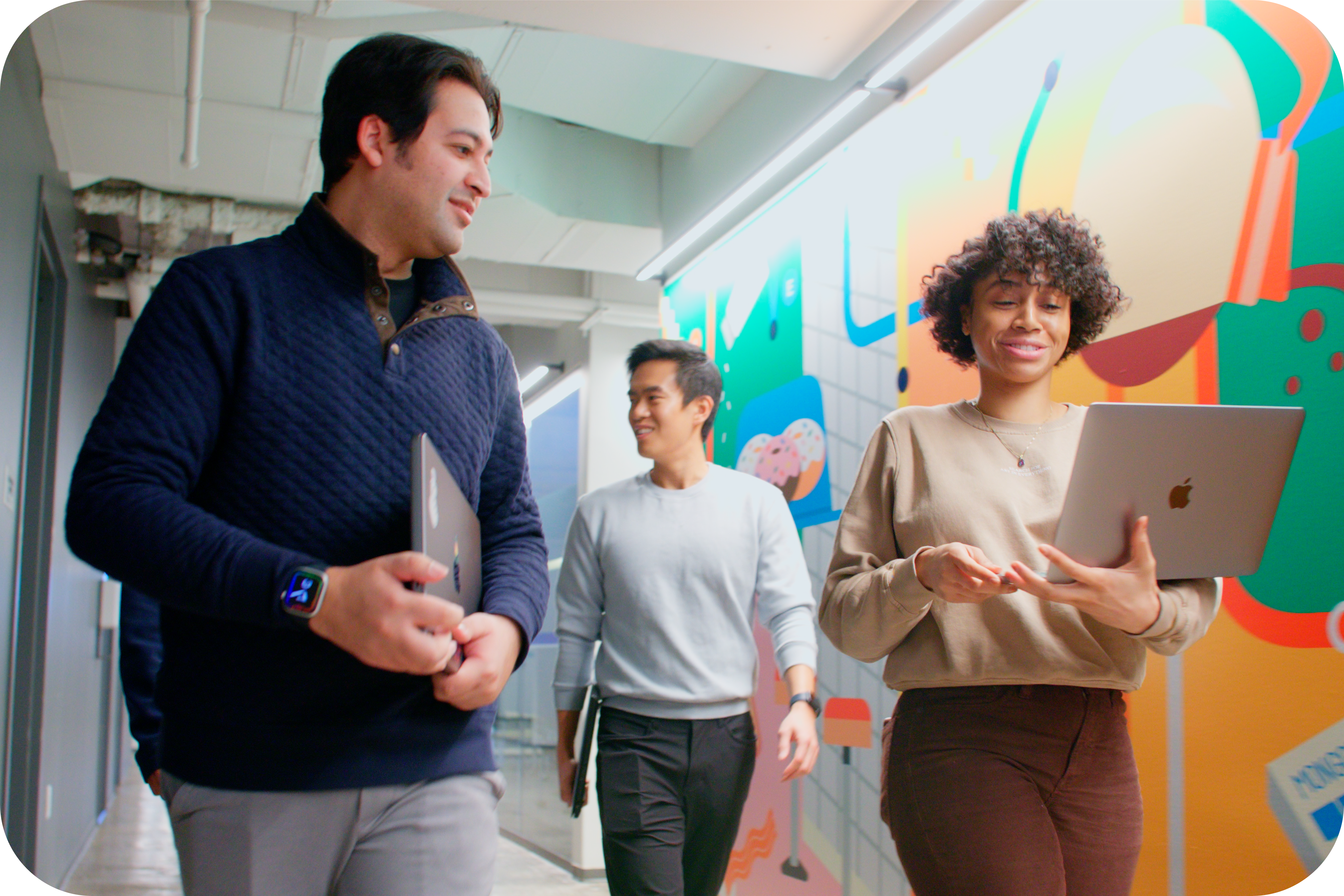 Photo of a woman with a laptop and two men in the office