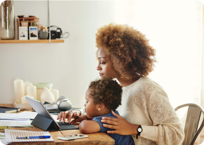 Mom working on a tablet with her son on her lap