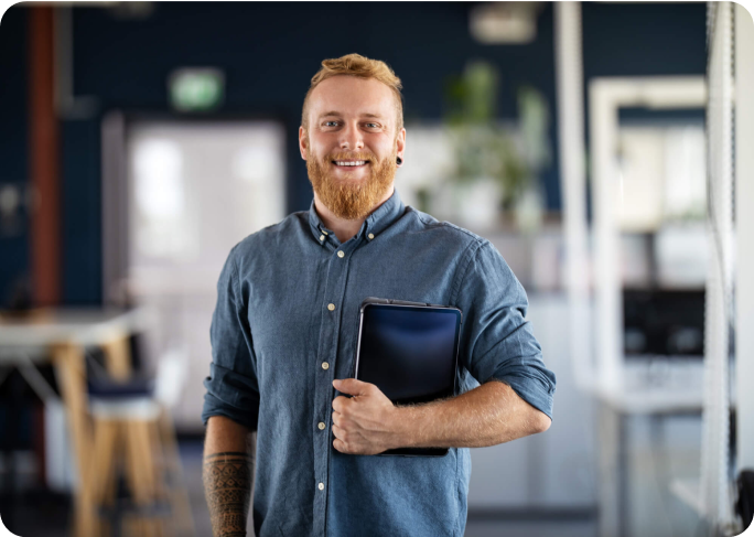 Man standing in an office with a tablet in his hand