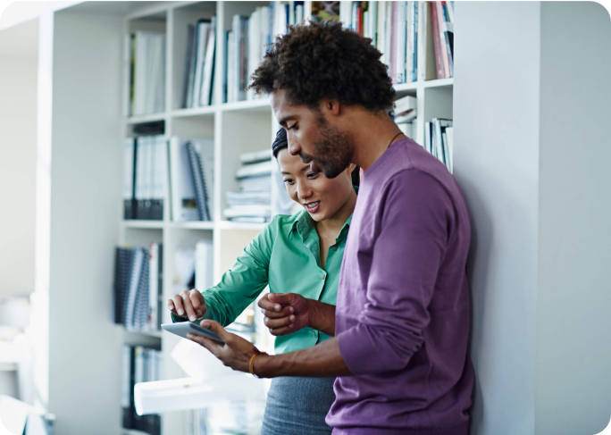 Man and woman looking at a cell phone in a casual office