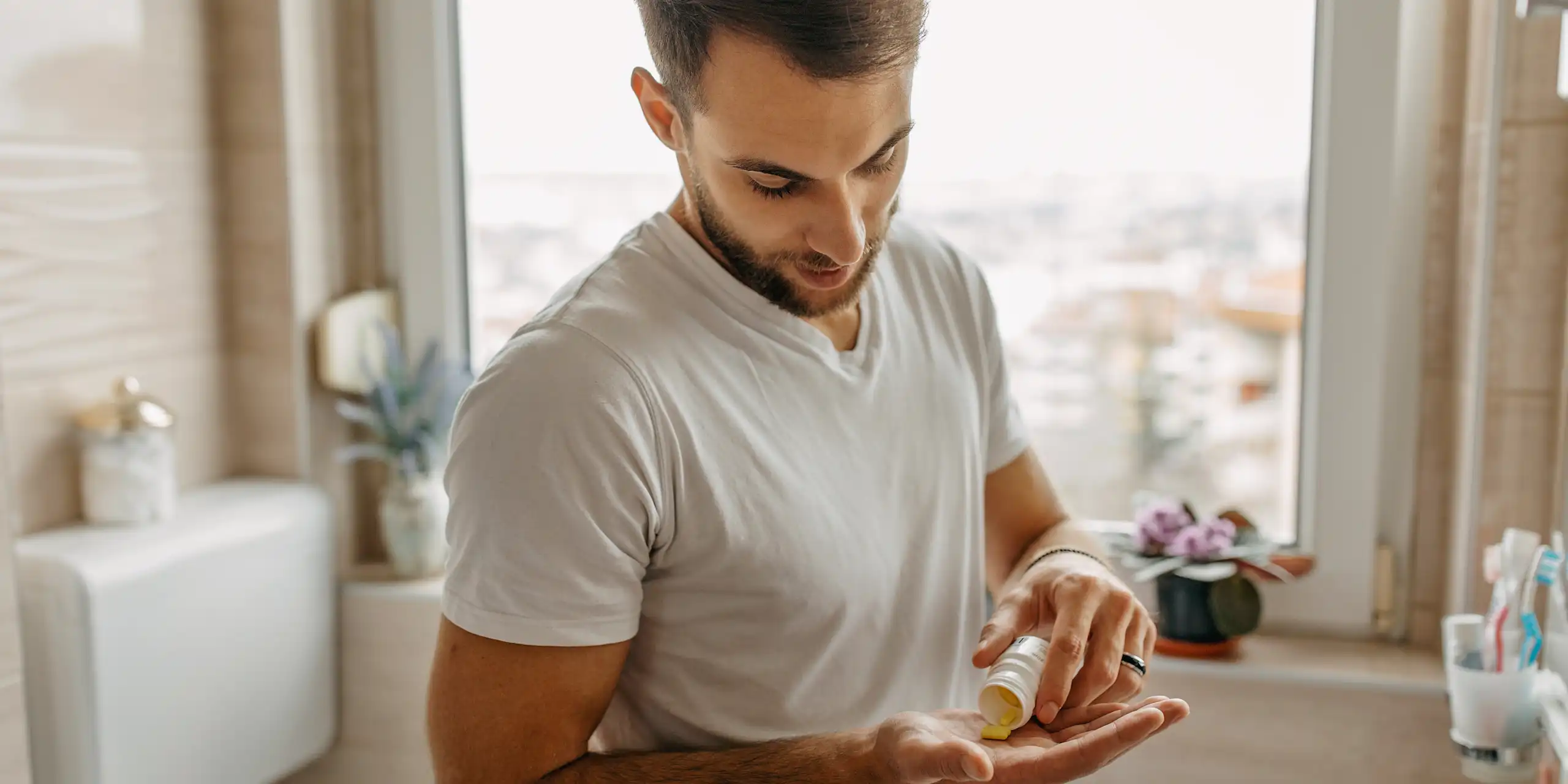Man takes a zinc tablet in his bathroom
