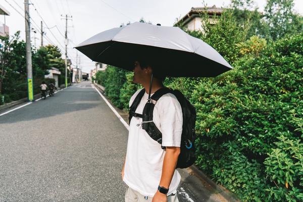 傘をさしても両手が空く。バックパックに固定するだけの小さな発明