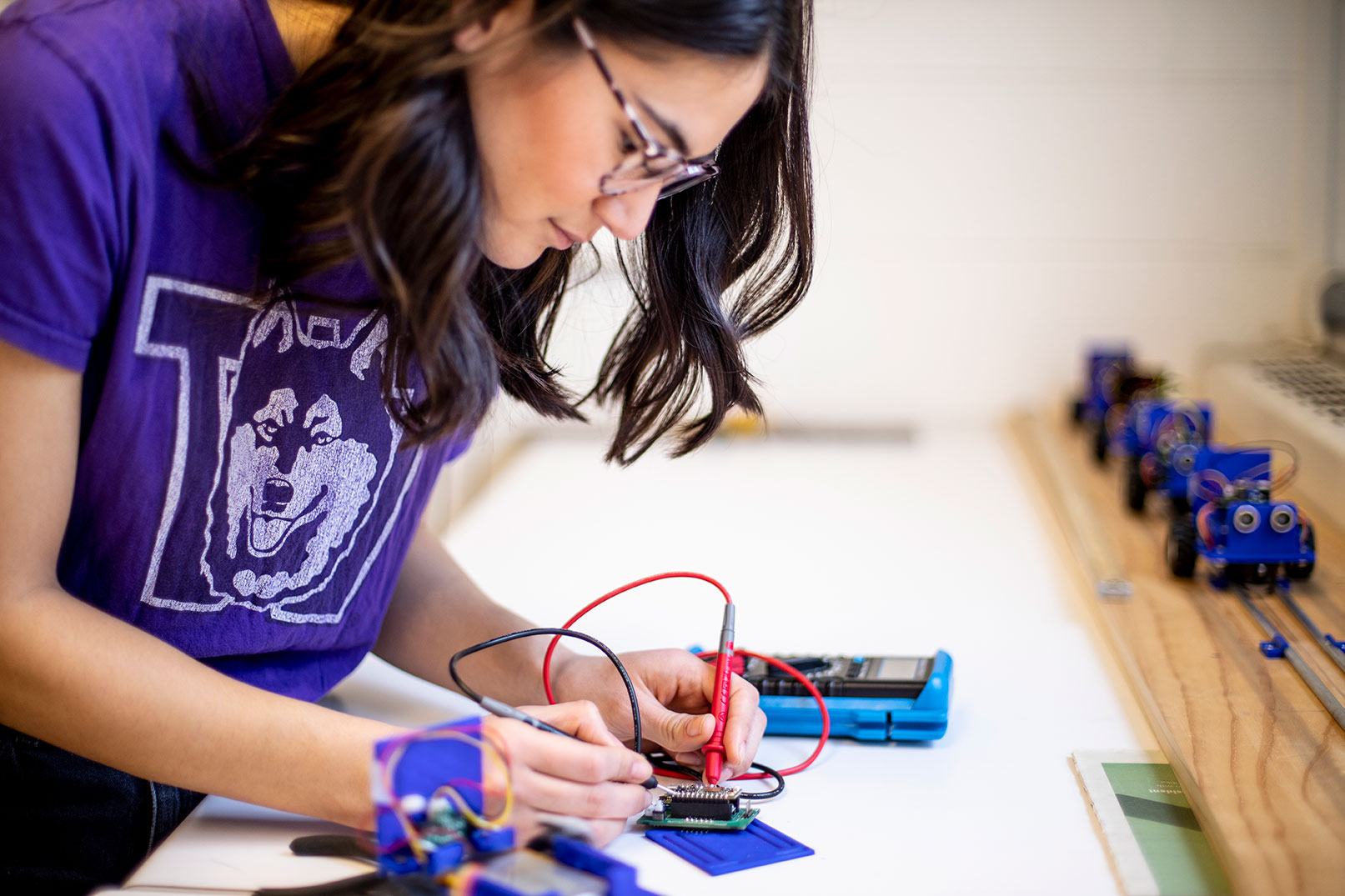 A person in UW shirt works on an engineering project