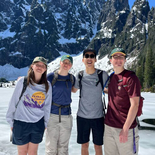 Students on a hike with mountains and a lake in the background