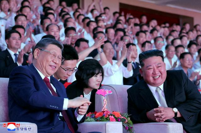平壌で2026年6月8日、中国の習近平国家主席(左)と北朝鮮の金正恩総書記が平壌体育館で公演を鑑賞した。習氏は眼鏡を着用していた。朝鮮中央通信が配信した=ロイター