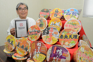 ヤマダイの大久保慶一社長と「ニュータッチ凄麺」シリーズ。商品は2025年にはグッドデザイン賞に輝いた=2026年6月9日午前11時57分、茨城県八千代町、古庄暢撮影